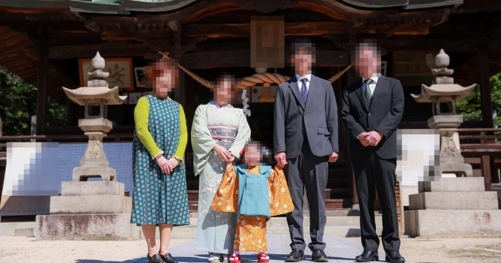 神社の前で並ぶ家族