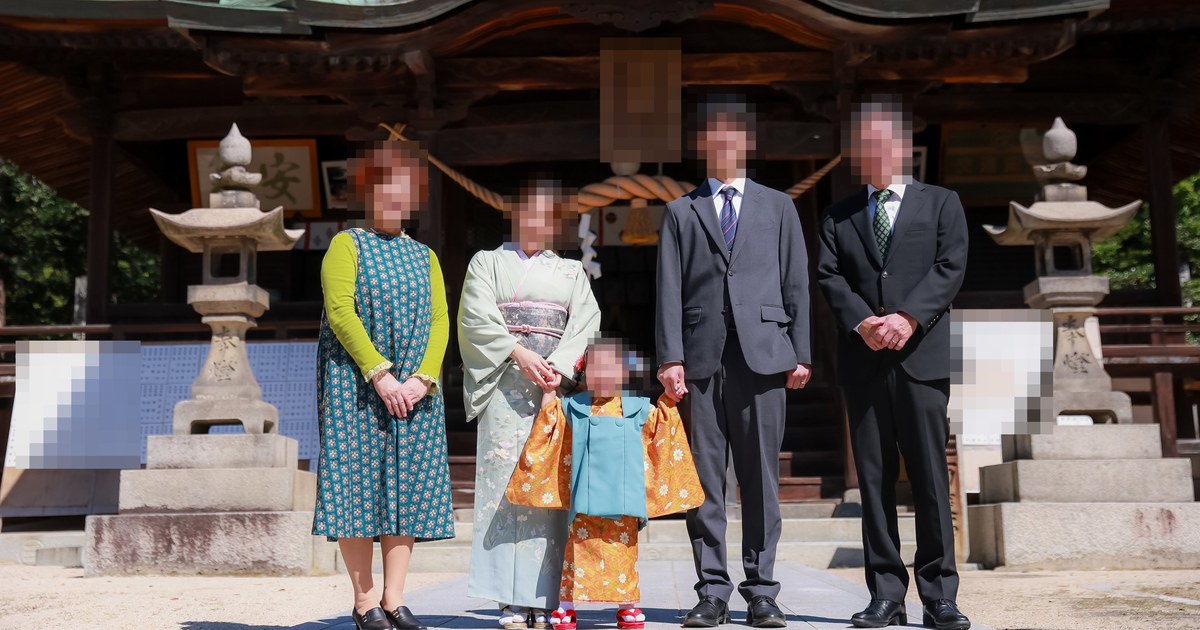 神社の前で並ぶ家族