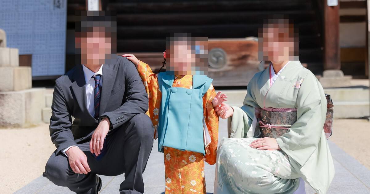 しゃがんで笑う家族3人